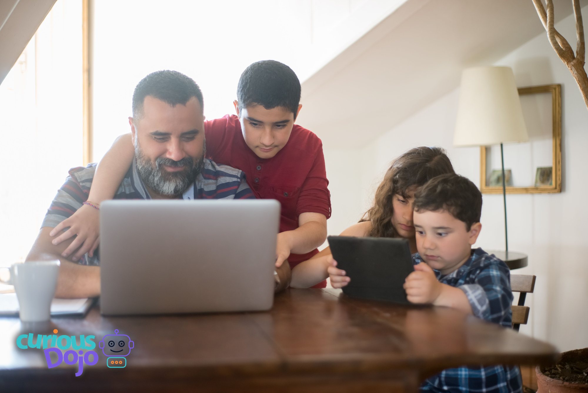 A parent helping two children use AI safely on a laptop at home, from CuriousDojo.